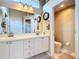 Well-lit bathroom boasts double sinks with white cabinets and a private toilet room at 380 Niblick Cir, Winter Haven, FL 33881