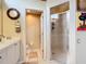 Bathroom featuring a clear glass shower door and vanity with a door leading to a toilet room at 380 Niblick Cir, Winter Haven, FL 33881