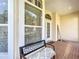 Cozy front porch featuring tiled floors, decorative windows, and a bench at 380 Niblick Cir, Winter Haven, FL 33881