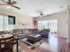 Spacious living room with a large sectional sofa, wood floors, and sliding glass doors to the lanai at 380 Niblick Cir, Winter Haven, FL 33881