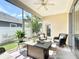 Relaxing screened lanai with neutral furniture, ceiling fan, and pleasant outdoor view at 380 Niblick Cir, Winter Haven, FL 33881
