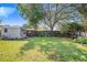 Large backyard featuring a shed, lush lawn, and mature trees, perfect for outdoor activities and storage at 40 Westridge Rd, Davenport, FL 33837