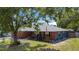 Inviting brick-and-painted home with a cozy front porch, complemented by mature landscaping and a well-kept lawn at 40 Westridge Rd, Davenport, FL 33837