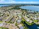 Wide aerial perspective showcasing neighborhood homes, water features, and a picturesque lake in the distance at 4100 Martindale Loop, Winter Haven, FL 33884