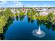 Aerial view of neighborhood pond with water feature and homes with lush trees at 4100 Martindale Loop, Winter Haven, FL 33884
