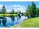 Beautiful view of backyard that showcases the lake and landscaping at 4100 Martindale Loop, Winter Haven, FL 33884