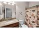 This bathroom has a granite countertop, wood cabinets, and a shower with a sea-themed curtain at 4100 Martindale Loop, Winter Haven, FL 33884
