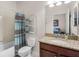 Bright bathroom features a granite countertop, wood cabinets, and a shower with a patterned curtain at 4100 Martindale Loop, Winter Haven, FL 33884