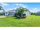 Landscaped lawn with flowering plants around the house and a two-car garage at 4100 Martindale Loop, Winter Haven, FL 33884