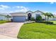 Well-maintained home featuring a two-car garage, beautiful landscaping, and a brick paved driveway at 4100 Martindale Loop, Winter Haven, FL 33884