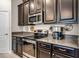 Close up of kitchen with stainless steel appliances, granite countertops, and dark wood cabinetry at 4100 Martindale Loop, Winter Haven, FL 33884