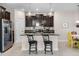 Kitchen island with bar stool seating, dark wood cabinets, stainless steel appliances, and pendant lighting at 4100 Martindale Loop, Winter Haven, FL 33884