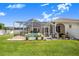 The backyard has a screened in pool, patio, and manicured lawn at 413 Ruby Lake Pl, Winter Haven, FL 33884