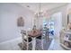 Bright dining area with elegant chandelier and view of pool and patio through sliding glass doors at 413 Ruby Lake Pl, Winter Haven, FL 33884