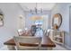 Elegant dining room featuring a long wooden table, modern chandelier, and view of the pool area through sliding doors at 413 Ruby Lake Pl, Winter Haven, FL 33884
