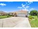 Lovely single-Gathering home with a two-car garage, lush green lawn, and mature landscaping, creating a welcoming curb appeal at 413 Ruby Lake Pl, Winter Haven, FL 33884