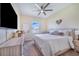 The primary bedroom features a ceiling fan, ensuite bathroom, and a large window for natural light at 413 Ruby Lake Pl, Winter Haven, FL 33884