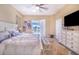 A primary suite features a ceiling fan, ensuite bathroom, and sliding door access to a private pool area at 413 Ruby Lake Pl, Winter Haven, FL 33884