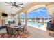 Screened patio with a ceiling fan, outdoor kitchen, and dining area overlooking a beautiful pool at 413 Ruby Lake Pl, Winter Haven, FL 33884