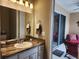 The bathroom includes a vanity and mirror adjacent to a sunroom with furniture at 421 Riders Loop, Auburndale, FL 33823