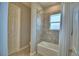 Bright bathroom featuring a shower-tub combination, light tile, and neutral paint at 421 Riders Loop, Auburndale, FL 33823