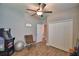 This is a secondary bedroom with wood floors, a ceiling fan, and a closet with paneled white doors at 421 Riders Loop, Auburndale, FL 33823