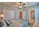 This is a bright bedroom featuring a ceiling fan and a spacious closet with white wood paneled doors at 421 Riders Loop, Auburndale, FL 33823