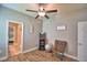 This is a secondary bedroom with wood floors, a ceiling fan, and a view of the walk-in closet at 421 Riders Loop, Auburndale, FL 33823