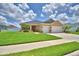 Inviting single-story home featuring a well-maintained lawn, desert landscaping, and a welcoming two-car garage at 421 Riders Loop, Auburndale, FL 33823