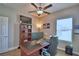 This home office boasts a ceiling fan, bright window, desk, and built-in shelving at 421 Riders Loop, Auburndale, FL 33823