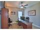 The cozy home office features a ceiling fan, desk, chair, and warm-toned walls at 421 Riders Loop, Auburndale, FL 33823