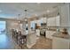 Bright kitchen featuring white cabinets, stainless steel appliances, and a large island with bar stool seating at 421 Riders Loop, Auburndale, FL 33823