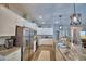 Spacious kitchen with stainless steel appliances, white cabinetry, an island with a sink, and pendant lighting at 421 Riders Loop, Auburndale, FL 33823