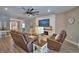 Cozy living room featuring a fireplace, plush seating, a ceiling fan, and wood-look flooring at 421 Riders Loop, Auburndale, FL 33823