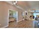Open-concept living space with an adjacent office, modern decor, and wood flooring at 421 Riders Loop, Auburndale, FL 33823