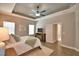 Bright and airy bedroom with tray ceiling, wood-look flooring, and an ensuite bathroom at 421 Riders Loop, Auburndale, FL 33823