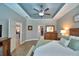 Cozy main bedroom offers a tray ceiling, ensuite bathroom, wood-look floors, and an open layout at 421 Riders Loop, Auburndale, FL 33823