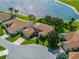 Aerial view of a charming one-story home with lush landscaping and a pond nearby at 4356 Ashton Club Dr, Lake Wales, FL 33859