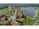 Aerial view of a one-story home in a neighborhood by a lake and golf course at 4356 Ashton Club Dr, Lake Wales, FL 33859