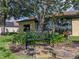 Landscaped backyard featuring a stone walkway, iron bench and flowering plants near the house at 4356 Ashton Club Dr, Lake Wales, FL 33859
