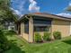 Beautiful home exterior with lush greenery, screened-in porch, and partial hurricane shutters on the windows at 4356 Ashton Club Dr, Lake Wales, FL 33859