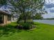 Lush green lawn and landscaping leading to serene lake views from the backyard at 4356 Ashton Club Dr, Lake Wales, FL 33859