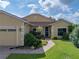 Charming one-story home featuring well-manicured lawn, brick driveway, and a cozy, inviting entrance at 4356 Ashton Club Dr, Lake Wales, FL 33859