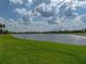 Expansive view of the lake and meticulously maintained lawn with palm trees in the background at 4356 Ashton Club Dr, Lake Wales, FL 33859
