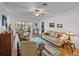 Inviting living room with ceiling fan, carpeting, and view of enclosed porch with dining table and chairs at 4356 Ashton Club Dr, Lake Wales, FL 33859