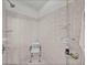 Modern shower space featuring tiled walls, a built-in seat, and convenient storage racks at 4356 Ashton Club Dr, Lake Wales, FL 33859