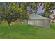 Spacious backyard featuring a screened-in lanai, lush lawn, and mature trees at 436 China Berry Cir, Davenport, FL 33837