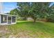Landscaped backyard with mature trees and screened in porch at 436 China Berry Cir, Davenport, FL 33837