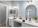 Stylish bathroom featuring double sinks, white cabinets, modern fixtures, and quartz counters at 436 China Berry Cir, Davenport, FL 33837