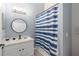 Bathroom featuring a single sink, storage vanity, modern mirror, and shower with a patterned curtain at 436 China Berry Cir, Davenport, FL 33837
